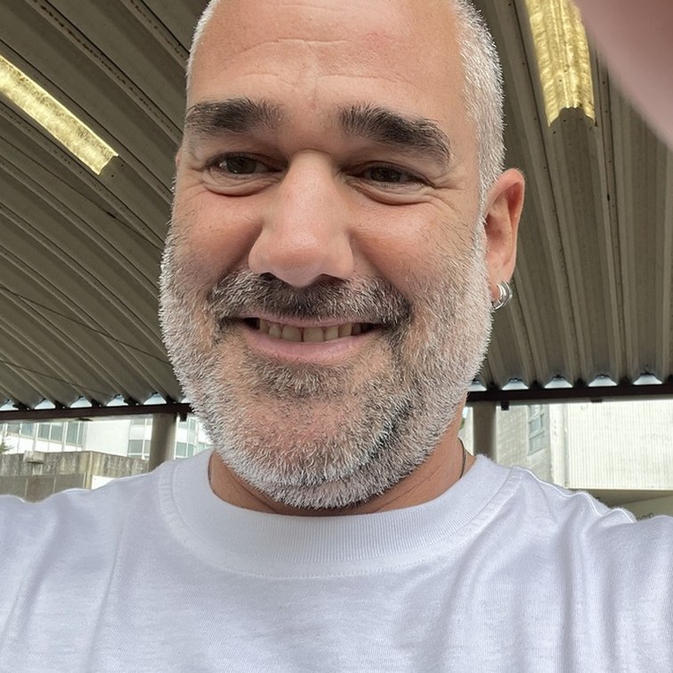 Retrato de Miguel Golmayo sonriendo bajo una cubierta de chapa